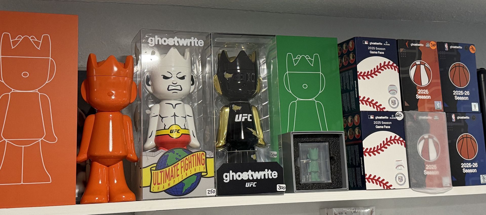 Ghostwrite UFC vinyl figures in their cases next to boxed collectibles